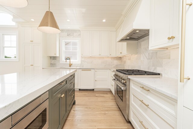 146 22nd St, Avalon, NJ 08202 - kitchen with custom range hood, stainless steel appliances, gray cabinetry, light wood-style floors, and recessed lighting