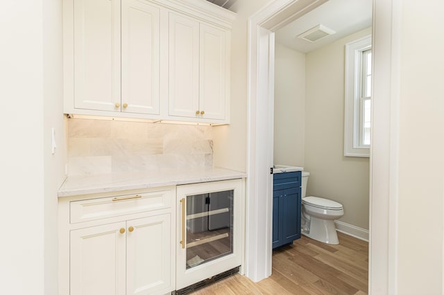 146 22nd St, Avalon, NJ 08202 - indoor dry bar with beverage cooler, light wood-style flooring, and decorative backsplash
