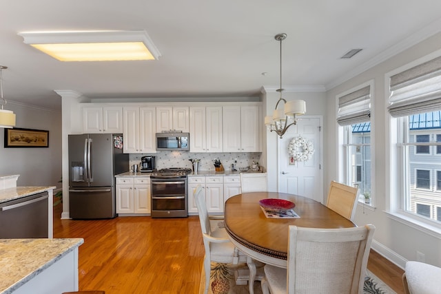 3401 Seaboard Cir Unit 3401, North Wildwood, NJ 08260 - kitchen with pendant lighting, appliances with stainless steel finishes, white cabinets, and light wood-type flooring