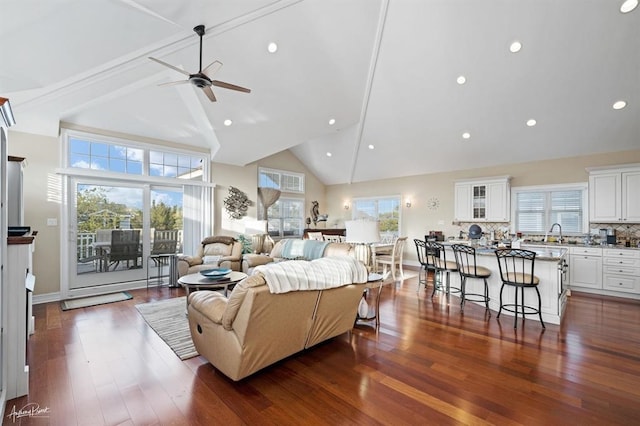 living room featuring dark wood-style floors, high vaulted ceiling, and baseboards