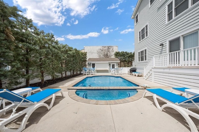 view of pool with a patio area, a hot tub, a fenced in pool, and an outdoor structure