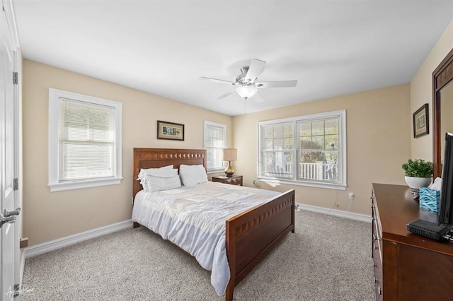 bedroom with light colored carpet, ceiling fan, and baseboards