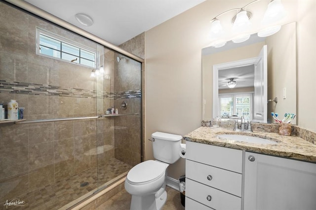 full bath with toilet, a shower stall, vanity, and baseboards