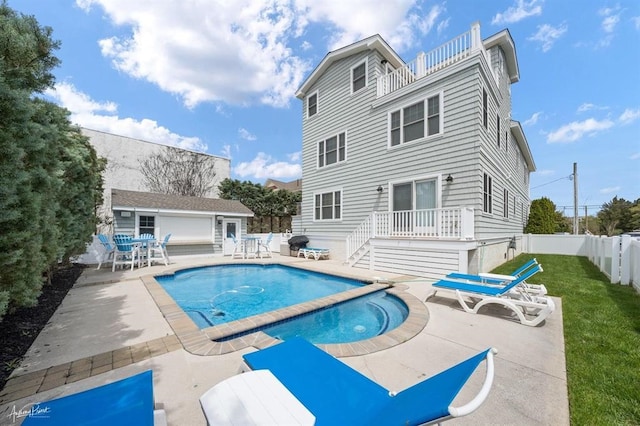 back of house with a fenced backyard, a balcony, an outdoor structure, a fenced in pool, and a patio area