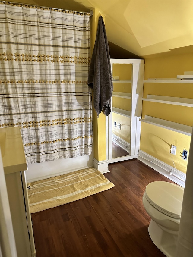 bathroom with hardwood / wood-style floors and lofted ceiling