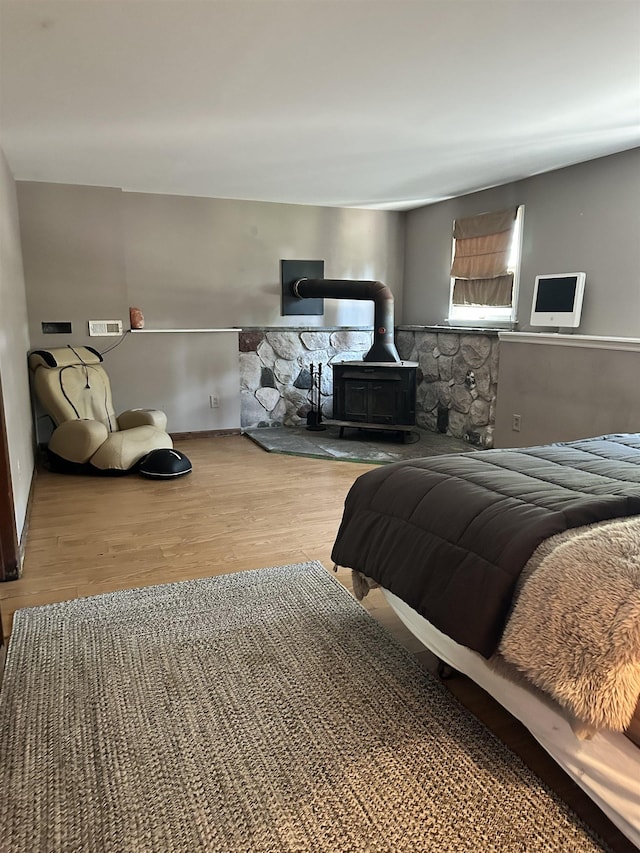 bedroom with light wood-type flooring and a wood stove