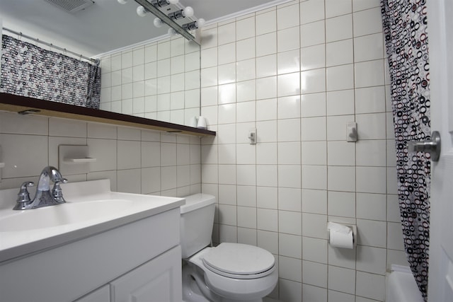 bathroom with tile walls, vanity, ornamental molding, and toilet