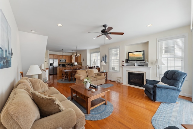 living room featuring light wood-type flooring and ceiling fan