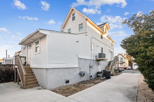 view of side of property featuring a residential view, crawl space, and stairway