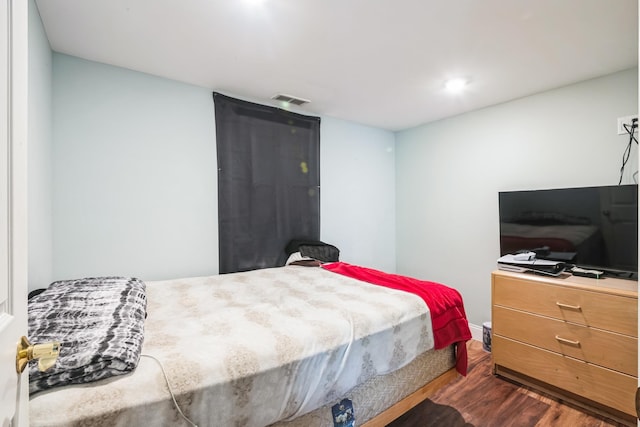 bedroom with dark wood-style floors and visible vents