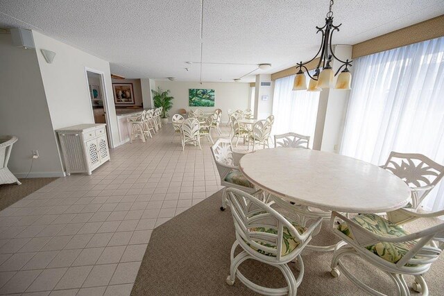 dining room with tile patterned floors, a textured ceiling, and a chandelier