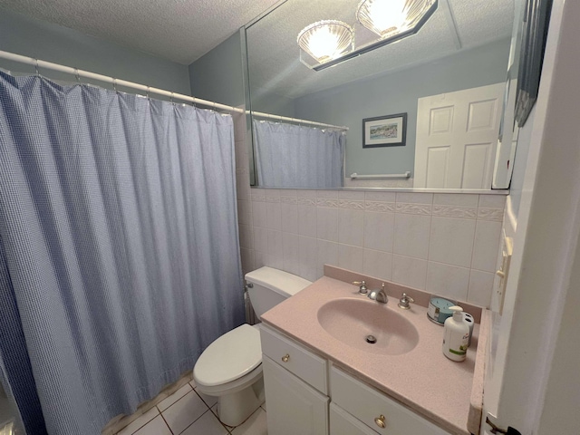 bathroom with walk in shower, a textured ceiling, toilet, vanity, and tile walls