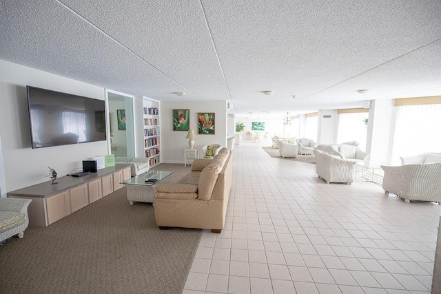 living room with light tile patterned floors, a textured ceiling, and a wall of windows