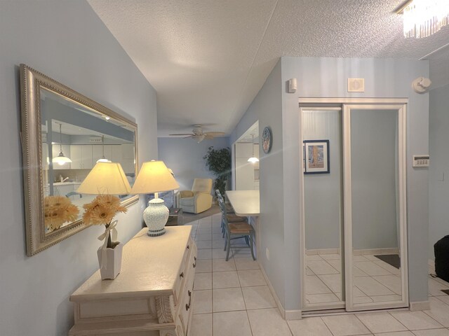 hallway with light tile patterned flooring and a textured ceiling