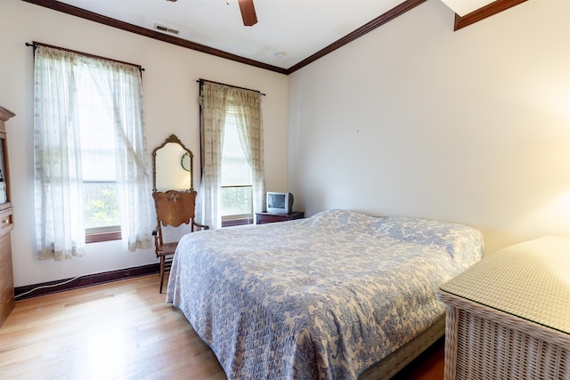 bedroom featuring multiple windows, light hardwood / wood-style floors, ceiling fan, and crown molding