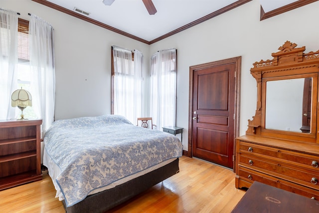 bedroom with ceiling fan, light wood-type flooring, and crown molding