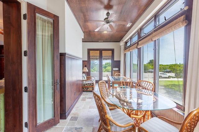 dining area featuring ceiling fan, french doors, wood ceiling, and wood walls