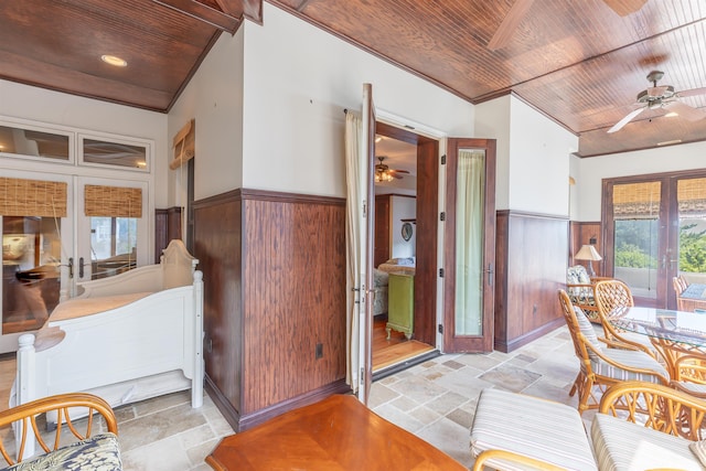 interior space featuring lofted ceiling, wood walls, wooden ceiling, and french doors