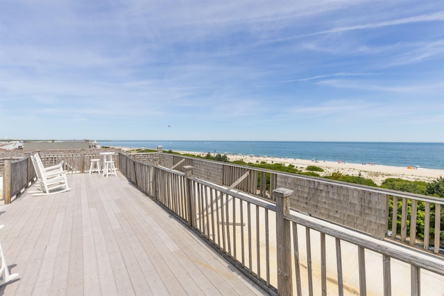 wooden deck with a beach view and a water view