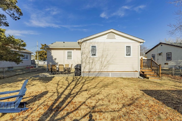 rear view of house featuring a fenced backyard and a lawn