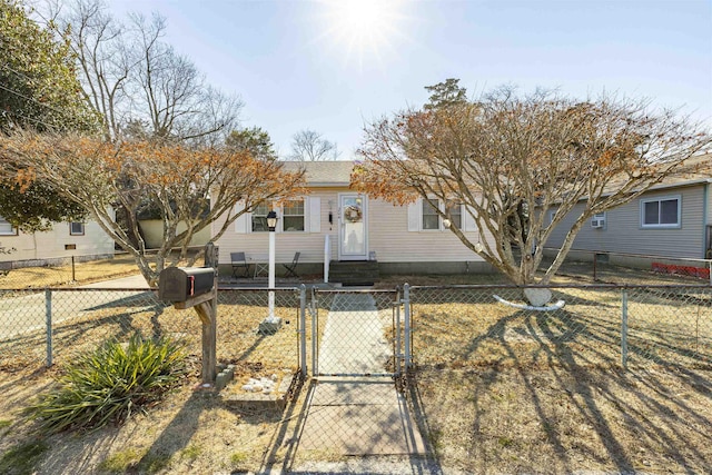 ranch-style home featuring a fenced front yard, entry steps, a gate, and roof with shingles