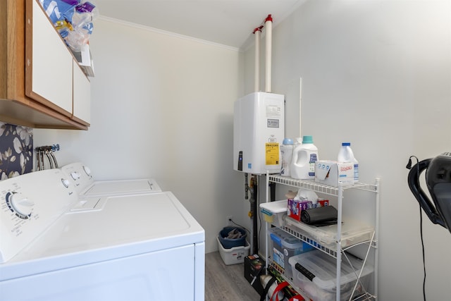 laundry room with crown molding, light wood finished floors, cabinet space, washing machine and dryer, and tankless water heater