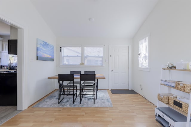 dining room featuring lofted ceiling and light wood-style flooring