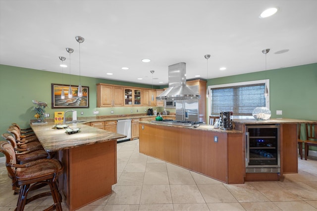 kitchen with stainless steel appliances, wine cooler, kitchen peninsula, pendant lighting, and island range hood