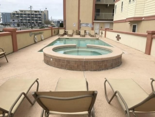 view of pool with a patio and a hot tub