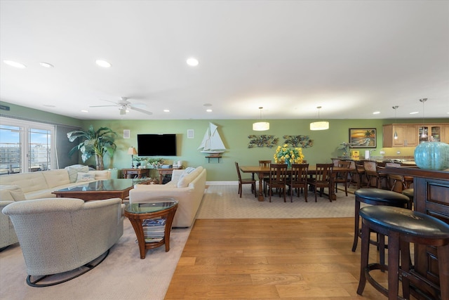 living room featuring ceiling fan and light hardwood / wood-style floors