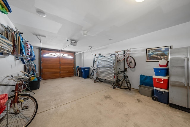 garage with stainless steel fridge and a garage door opener