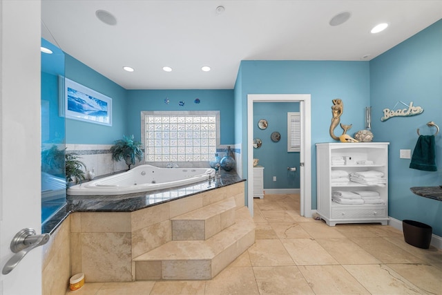 bathroom with tile patterned flooring and tiled tub