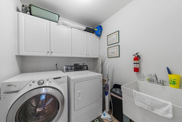 laundry area with cabinets, washer and dryer, and sink