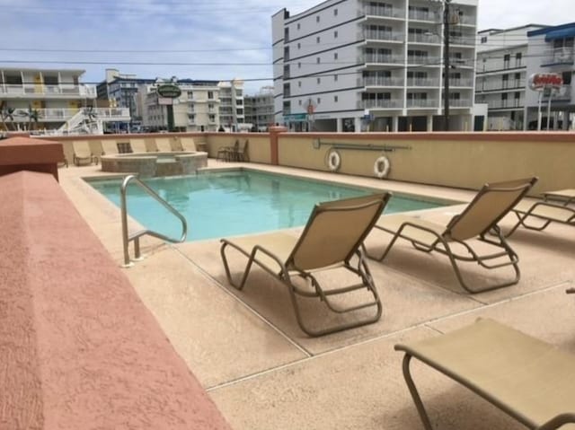 view of swimming pool featuring a community hot tub