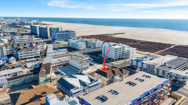 drone / aerial view featuring a beach view and a water view