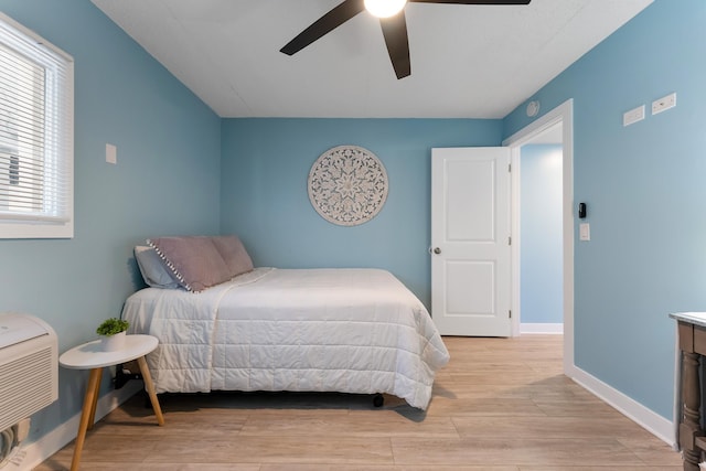 bedroom with ceiling fan, light wood-style flooring, and baseboards