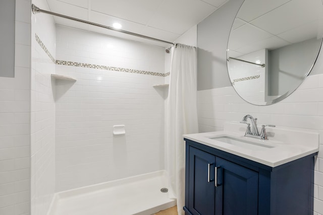 bathroom with tile walls, vanity, and a shower stall