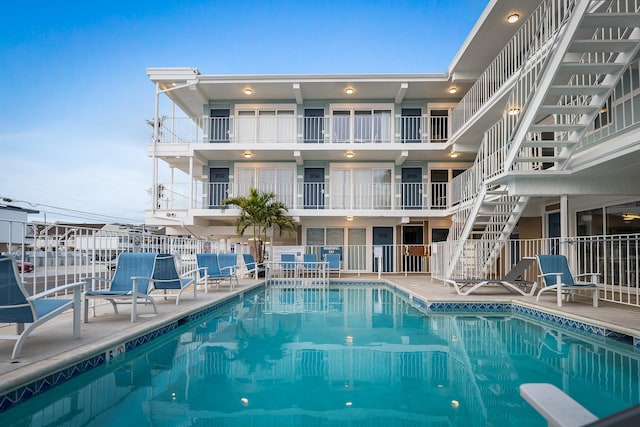 community pool with a patio area and fence