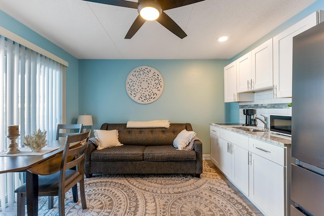 living room with baseboards and a ceiling fan