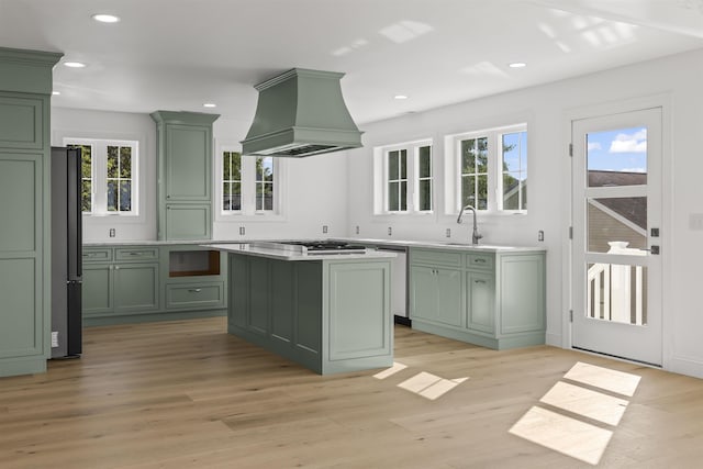 9 N 8th St, Del Haven, NJ 08251 - kitchen with green cabinets, custom exhaust hood, light wood-style flooring, appliances with stainless steel finishes, and light countertops