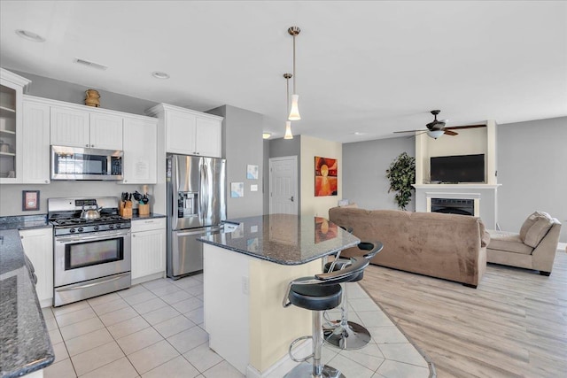 240 E Taylor Ave Unit 100, Wildwood, NJ 08260 - kitchen featuring stainless steel appliances, white cabinets, a center island, a breakfast bar, and glass insert cabinets