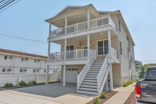240 E Taylor Ave Unit 100, Wildwood, NJ 08260 - coastal inspired home featuring a balcony, stairs, an attached garage, concrete driveway, and a porch