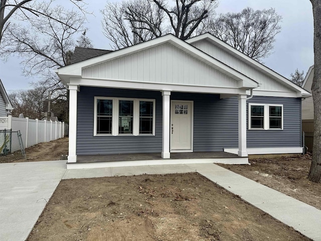 bungalow featuring covered porch and fence