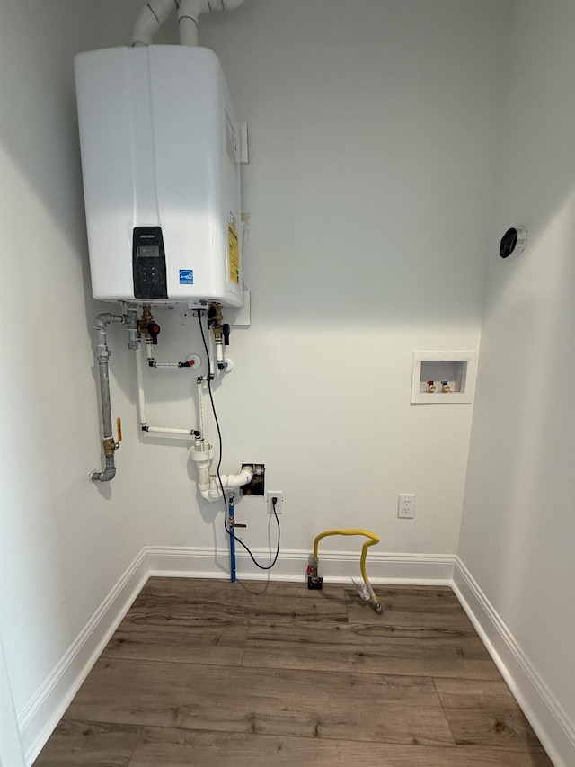 laundry room featuring tankless water heater, laundry area, washer hookup, baseboards, and dark wood-style floors