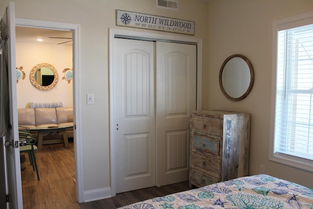 bedroom featuring dark hardwood / wood-style flooring, a closet, and multiple windows