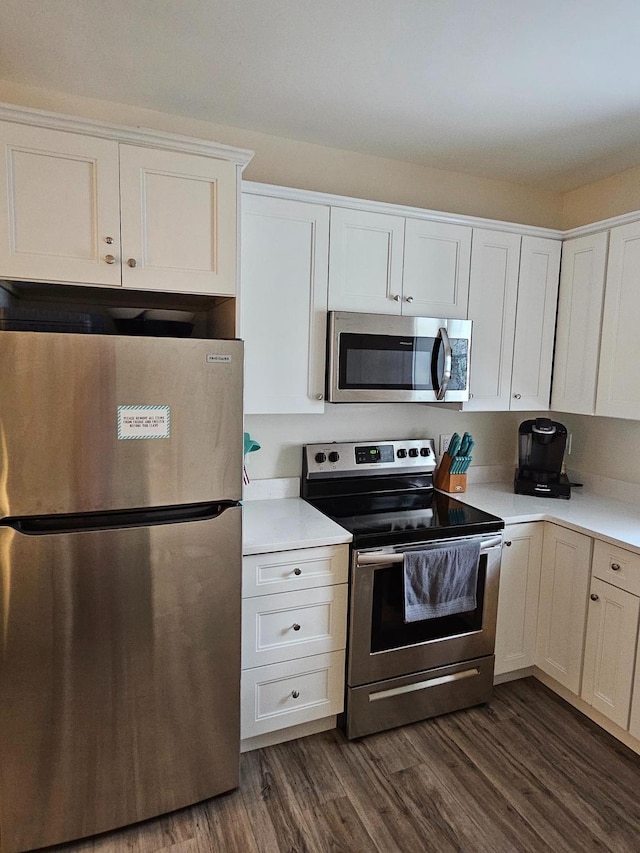 kitchen with white cabinetry, dark hardwood / wood-style flooring, and appliances with stainless steel finishes