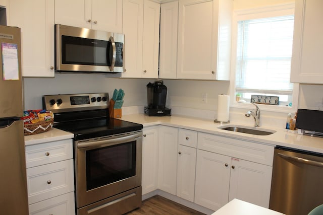 kitchen with appliances with stainless steel finishes, white cabinetry, and sink