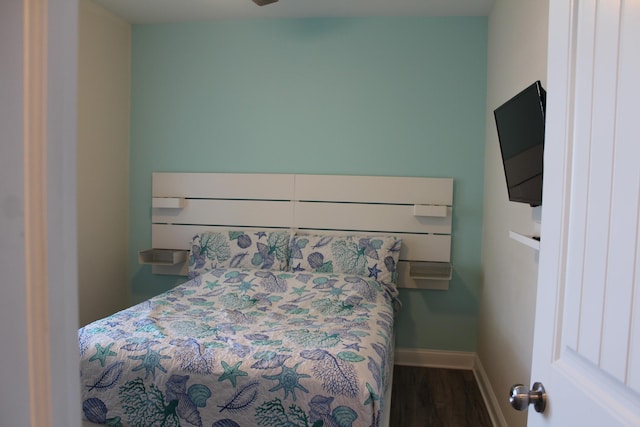 bedroom with dark hardwood / wood-style flooring