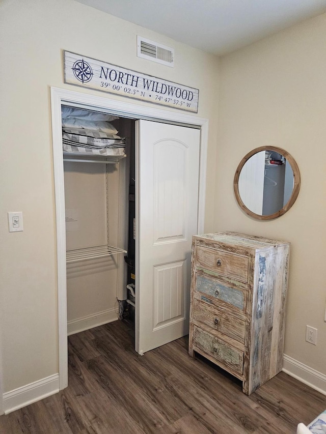 unfurnished bedroom featuring a closet and dark hardwood / wood-style flooring