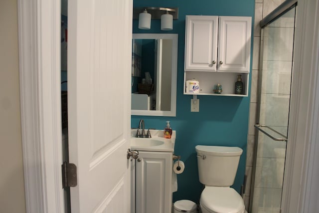 bathroom with vanity, toilet, and a shower with shower door